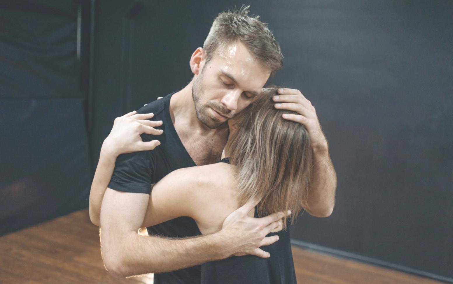 Coppia che danza salsa in sala prove illuminata